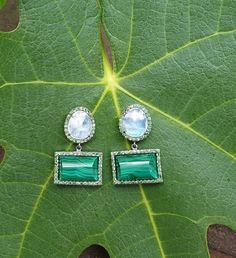 With their earthy elegance and vibrant combination of colors, these earrings also add a playful sophistication to any collection. The slightly domed malachite and faceted rainbow moonstone are framed by sparkling tsavorite stones. As casual or as dressy as you like, these earrings exude a playful, sophisticated style. Total length : 30mm malachite stone : 15mm x 12mm You might also like: https://www.etsy.com/listing/649858864/diamond-eearrings-crystal-quartz-and?ref=shop_home_active_22 Wear thes Green Fusion Dangle Earrings, Fusion Green Earrings With Natural Stones, Green Natural Stones Fusion Earrings, Green Fusion Earrings With Natural Stones, Green Multi-stone Drop Earrings, Green Natural Stone Fusion Earrings, Green Emerald Multi-stone Earrings, Elegant Green Earrings With Natural Stones, Green Drop Earrings With Gemstone Accents