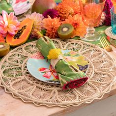 a place setting with plates, napkins and flowers