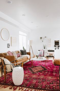 a living room filled with lots of furniture and rugs on top of a hard wood floor