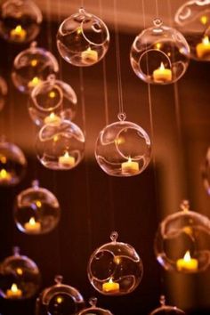 some clear balls with candles hanging from them