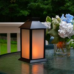 a vase filled with flowers sitting on top of a table next to a lit candle