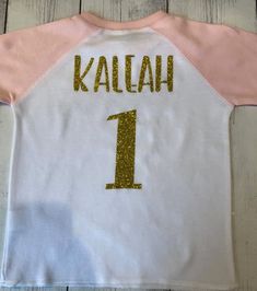 Personalized 2 year old girl Birthday Shirt, Girls 2nd Birthday Shirt, 2nd Birthday Outfit, Pink Second Birthday Outfit, Two Shirt for Girl Your little lady will look beyond adorable in this pink Ragaln Birthday Shirt with her age displayed proudly across the front of her shirt! You can also add your little ones name and age on the back of this shirt. To do so make sure to select the option from the drop down box that says Shirt/name&age. If the option Shirt Only is selected, no name or age Pre-shrunk Pink Shirt For Birthday, Pink Number Print T-shirt For Birthday, Cute Number Print Tops For Birthday, Pink Crew Neck Top For First Birthday, Pink Letter Print Top For Birthday, Pink Letter Print Shirt For Birthday, Cute Tops With Number Print For Birthday, Pink Crew Neck Top For Birthday, Pink Short Sleeve T-shirt With Number Print