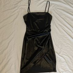 a black dress laying on top of a white sheet