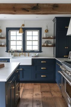 a kitchen with blue cabinets and white counter tops, gold pulls on the drawers and brass knobs