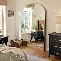 a bedroom with a bed, dresser and mirror on the wall in front of it