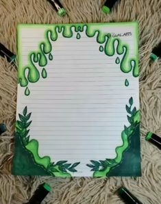 a notepad with green ink on it sitting on top of a pile of crayons