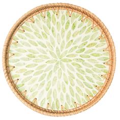 a round wicker basket with green leaves painted on it