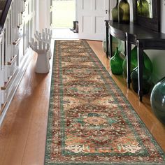 a large rug is on the floor in front of a doorway with green vases