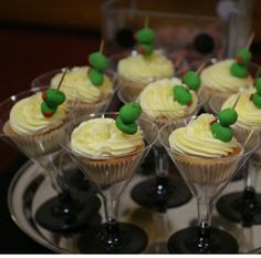 cupcakes with white frosting and green sprinkles are on a tray