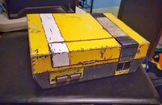 an old yellow box sitting on top of a table