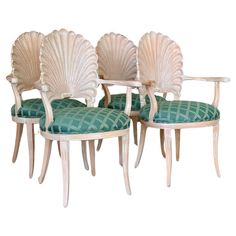 three shell back chairs with green upholstered cushions