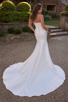 a woman in a wedding dress standing outside