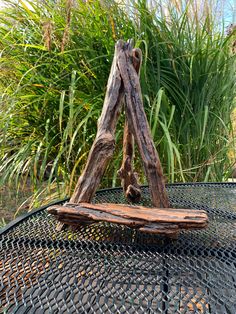 a piece of wood sitting on top of a grill grate next to some plants