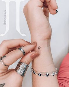 two women with matching rings on their wrist and one holding the other's hand