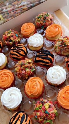 a box filled with cupcakes covered in frosting and zebra print icing