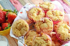 some muffins and strawberries on a table next to a bowl of milk