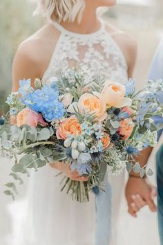 a bride holding a bouquet of flowers in her hands while standing next to another person