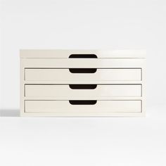 a white dresser with three drawers and black lines on the bottom drawer, against a white background