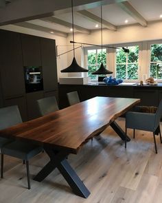 a large wooden table sitting in the middle of a kitchen