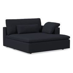 a black couch with two pillows on it and one arm folded up to the side