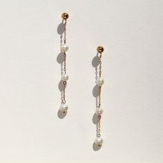 Absolutely stunning on, these tiny triple tiered freshwater pearls float on delicate 14k gold filled chain. The 3mm wide pearls set along a whisper of chain, create a super chic minimal look that will offset a harder masculine outfit, and work equally well with feminine, bridal looks.  The ball ear post and backing are both 14k gold filled. 14k gold filled metal does not flake off and contains significantly more gold than regular 'gold plated' jewelry. It is considered second in quality to solid Cheap Minimalist Pearl Earrings With Pearl Charm, Dainty Pearl White 14k Gold Filled Pearl Earrings, 14k Gold Dangle Linear Earrings With Pearl Drop, 14k Gold Drop Pearl Earrings With Pearl Chain, 14k Gold Pearl Chain Drop Earrings, Delicate Pearl Chain Earrings For Everyday, Dainty Pearl Linear Earrings For Formal Events, Delicate Everyday Pearl Earrings With Chain, Dainty Linear Earrings With Pearl Charm For Gift