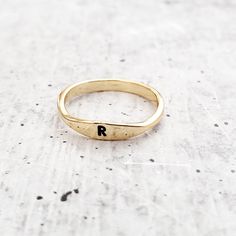 This minimalist finger band is hand stamped with your single upper case initial. It's a great, understated jewelry piece to accessorize and wear everyday.  Crafted with love and sprinkled with a touch of whimsy, this dainty ring features a sterling silver or shiny gold plating that's sure to make you feel like a superstar.  THIS GOLD PLATED RING IS VERY DAINTY.  All rings come beautifully and simply packaged in a box and bow ready for gifting. ABOUT THE ITEM ** The ring is made with sterling sil Understated Jewelry, Silver Initial Ring, Finger Band, Gold Initial Ring, Silver Stacking Rings, Initial Ring, Gold Initial, Upper Case, Plated Ring