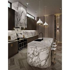 a large kitchen with marble counter tops and wooden flooring, along with two pendant lights hanging from the ceiling