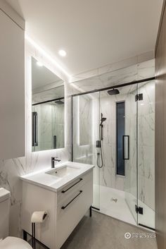 a bathroom with a sink, toilet and shower stall in it's center area