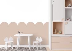 a white table and chairs in front of a wall with a beige scalloped design