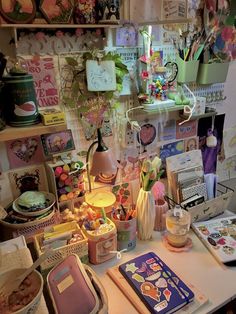 a cluttered desk with many items on it and a lamp in the corner next to it