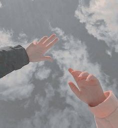 two hands reaching out towards each other in the sky