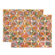 two placemats with an abstract design on the front and one has orange, green,