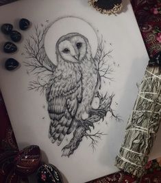 an owl sitting on top of a piece of paper next to a pen and ink