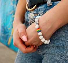 Introducing the Simple Volcanic Stone Bracelet from RoseGoldCo - a trendy and stylish accessory that is perfect for adding some personality and flair to your outfit. This bracelet features a rainbow design that shows your support for the LGBTQ+ community and adds a pop of color to your look. Crafted from high-quality volcanic stone, this bracelet is not only durable but also has energy stone properties that can provide a sense of calm and grounding. The rainbow design adds a touch of personality Trendy Jewelry For Pride Gifts, Gay Pride Bracelet, Stone Properties, Bracelet Rainbow, Pride Bracelet, Fashionable Accessories, Volcanic Stone, Stone Bracelets, Energy Stones