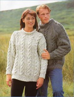 two people standing next to each other wearing sweaters