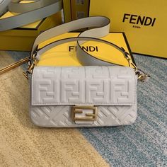 Iconic medium Baguette bag made of white soft nappa leather with a three-dimensional texture FF motif. Decorated with an FF clasp.Featuring a front flap, magnetic clasp, lined internal compartment with zip pocket and gold-finish metalware.The bag can be carried by hand, or either on the shoulder or cross-body thanks to the handle and shoulder strap, both detachable. Fendi Art, Art Purse, Fendi Baguette Bag, Baguette Recipe, Ootd Instagram, Fendi Fashion, Luxury Love, Fendi Bag, Fendi Handbags