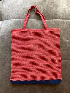 a red and blue bag sitting on top of a couch