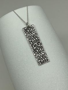 This Modern Boho Flower Burst Bar Necklace is handmade using .950 sterling silver. It has been cut from sterling silver precious metal clay, textured, fired and oxidized. The pendant hangs from a sterling silver diamond cut cable chain. This fine silver pendant features an embossed Mod Deco style flower burst textured pattern. Pendant size: approximately 1 1/2 x 7/16 inches Chain length: adjustable at 16 and 18 inches can also be customized to whatever length needed The necklace is sent in a gif Silver Etched Necklace With Flower Pendant, Silver Rectangular Etched Necklace, Etched Sterling Silver Necklaces, Silver Etched Sterling Silver Necklace, Silver Etched Rectangular Pendant Jewelry, Sterling Silver Etched Rectangular Pendant Jewelry, Etched Sterling Silver Rectangular Pendant Jewelry, Sterling Silver Stamped Necklace With Rectangular Pendant, Silver Stamped Rectangular Pendant Necklace