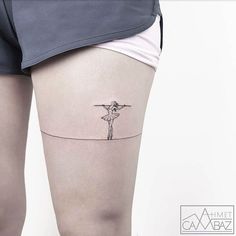 a woman's thigh with a line drawing of a person holding a cross on it