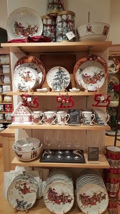 there are many plates and cups on the shelves in this store that is filled with christmas themed dishes