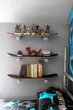 two skateboard shelves are above a bed with books and toys on top of them