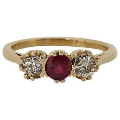 A tailored three stone ring featuring a center ruby weighing approximately 0.35 carat illuminated by two European cut diamonds weighing approximately 0.40 carat total mounted in 14 karat yellow gold. Current size 6.75. Three Stone Ring, European Cut Diamonds, Three Stone Rings, Ring Vintage, Vintage Diamond, Three Stone, Stone Ring, Gold Bands, Stone Rings