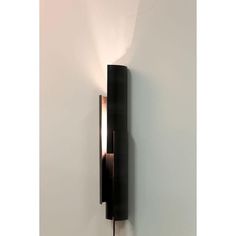 a black wall light mounted to the side of a white wall