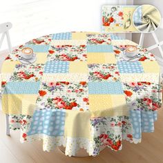 a round table covered with a yellow and blue checkered tablecloth next to a white chair