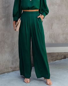 Relaxed Fit 100% Polyester Hand Wash Cold. Dry Flat High Rise Back Elastic Waistband Side Pockets Wide Pant Leg Satin Fabrication No Closures Not Lined Be the main character everywhere you go in this dark green colored set! Our Tamra Pocketed Satin Pants feature a smocked waist. These silky pants are designed with wide pant legs and a high rise. Styled with the Perfect Hoop Earrings. Find Your Way Compass Disc Necklace. Compass Coin Necklace. Stella Crossbody Envelope Zip Clutch. Simple Bangle B Be The Main Character, Silky Pants, Simple Bangle, Green Fits, Satin Pants, Wide Pants, Main Character, Trendy Tops, Fashion Brand