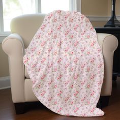 a white chair with a pink flowered blanket on it