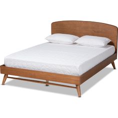 a bed with white pillows and wooden headboard