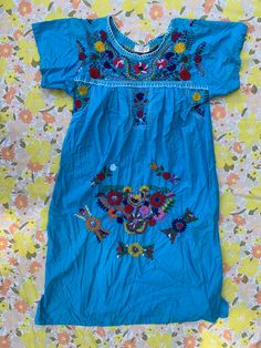 Boho Blue Embroidered Dress Made in Mexico 100% cotton Blue dress with multi-color embroidered floral patterns Measures: 42" length 4.5" sleeve 22" pit to pit (B12) Light Blue Cotton Bohemian Dress, Blue Fitted Folk Dress, Summer Blue Embroidered Floral Print Dress, Blue Floral Print Embroidered Summer Dress, Blue Floral Embroidery Short Sleeve Dress, Blue Folk Style Embroidered Long Sleeve Dress, Blue Folk Style Long Sleeve Embroidered Dress, Embroidered Light Blue Cotton Dress, Folk Style Embroidered Cotton Dress