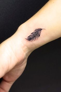 a small feather tattoo on the wrist