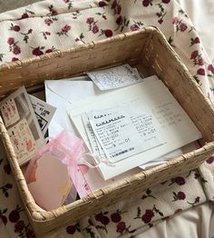 a wicker basket filled with lots of papers and cards on top of a bed